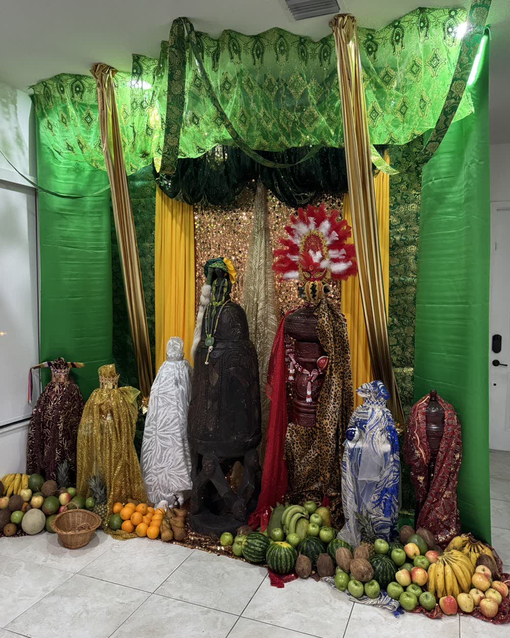 Trono verde y oro con soperas vestidas y ofrendas de frutas